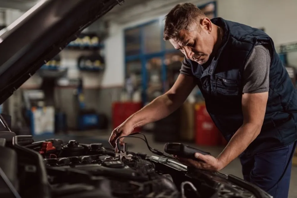 Mechanic testing a car battery
